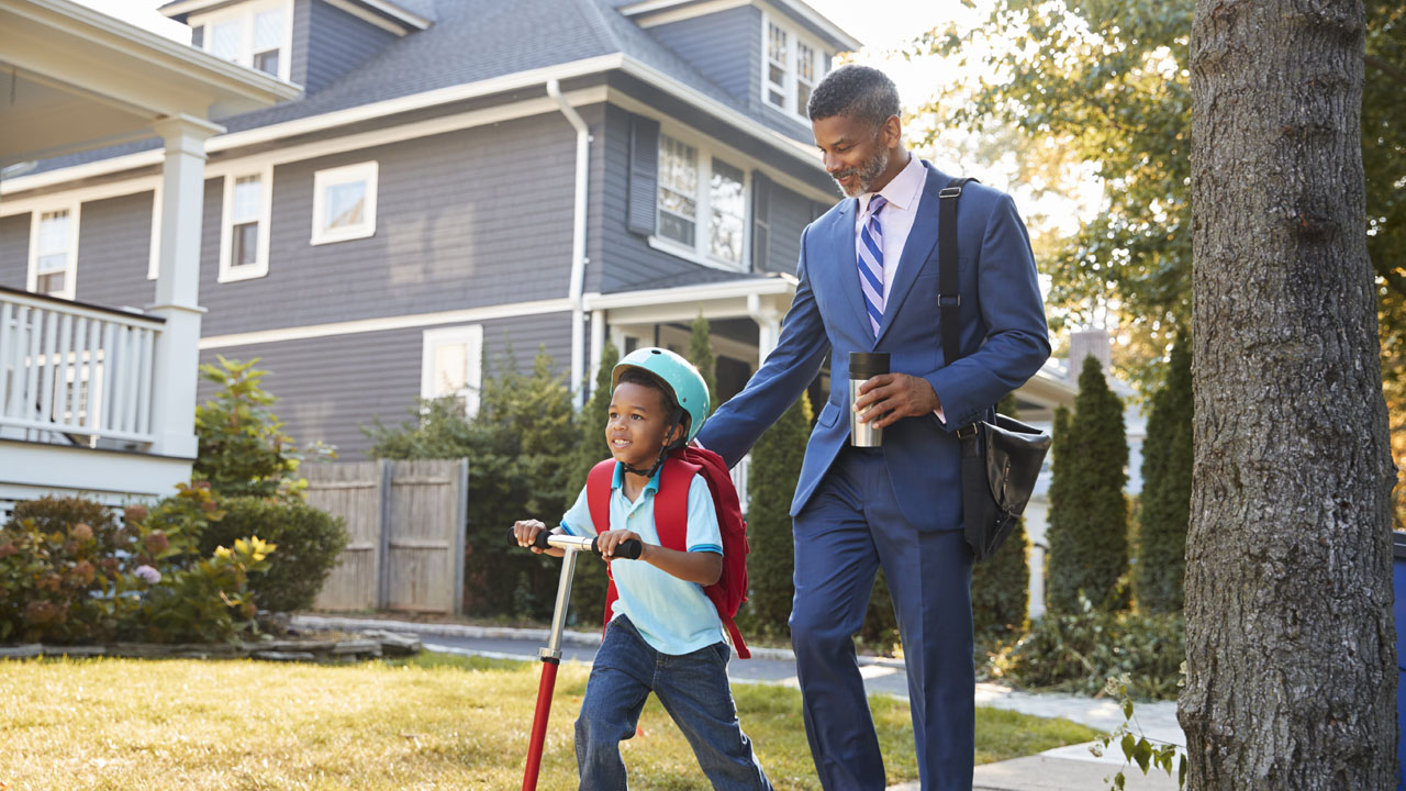 The father is taking his son outside using his scooter